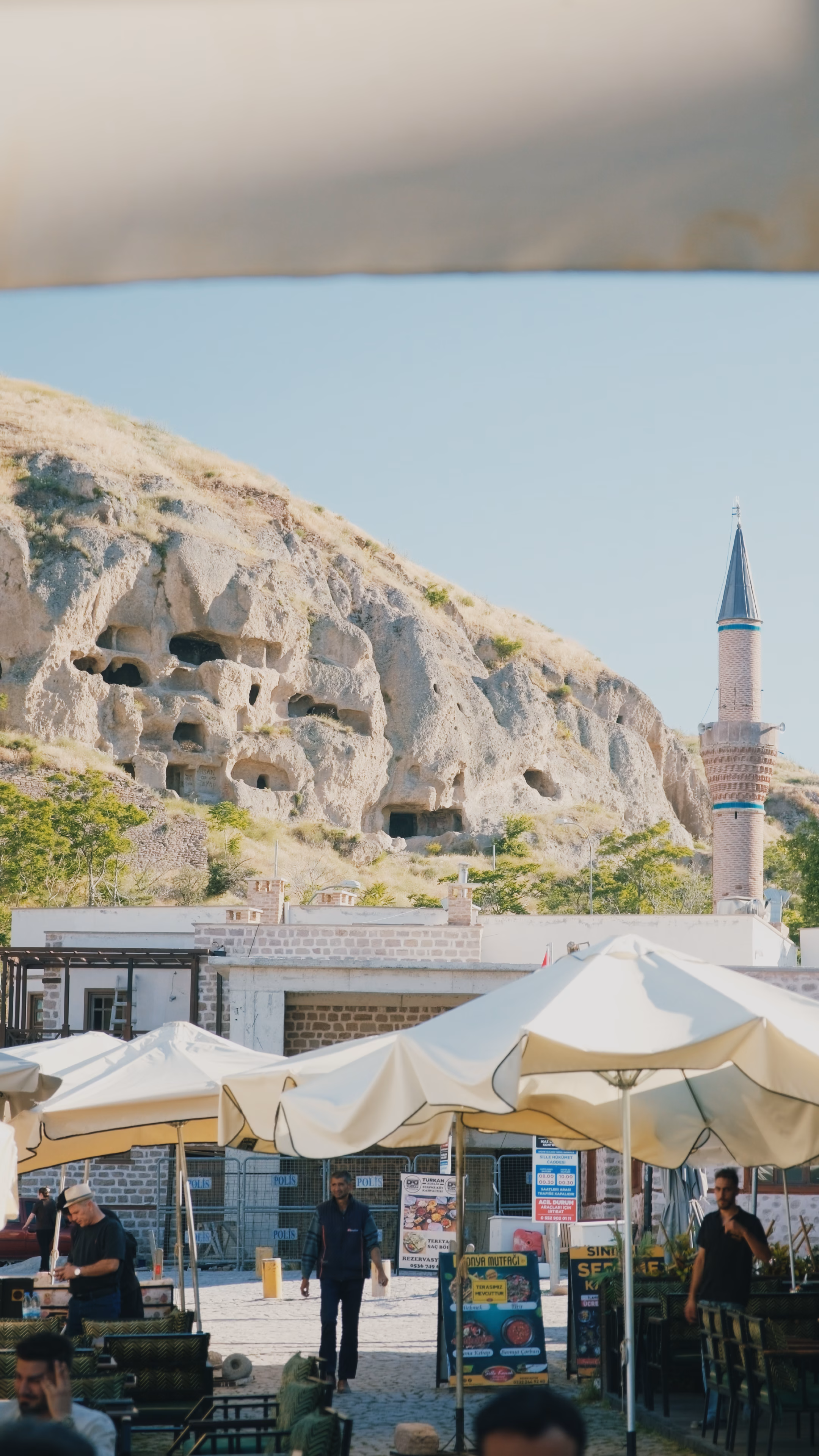 Sille'nin kayalığa oyulmuş tarihi merkezi, minare ve meydandaki güneş şemsiyeleri